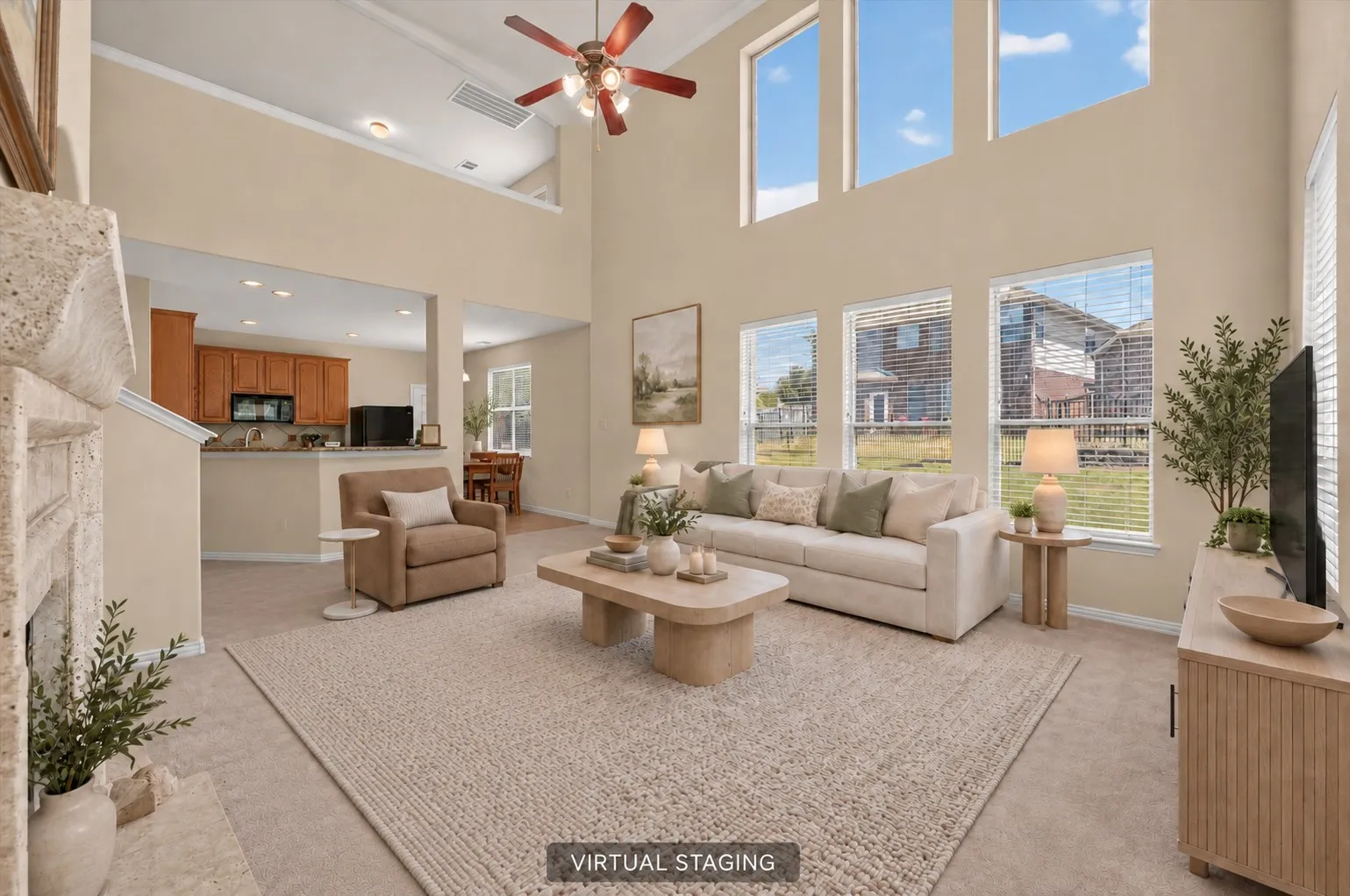 Two-story living area featuring a decorative stone-clad fireplace and high ceilings