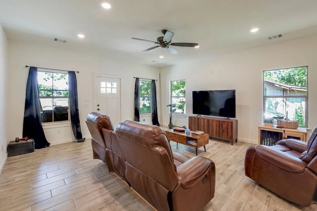 Light wood-finish flooring, recessed lighting, and a ceiling fan with integrated lighting