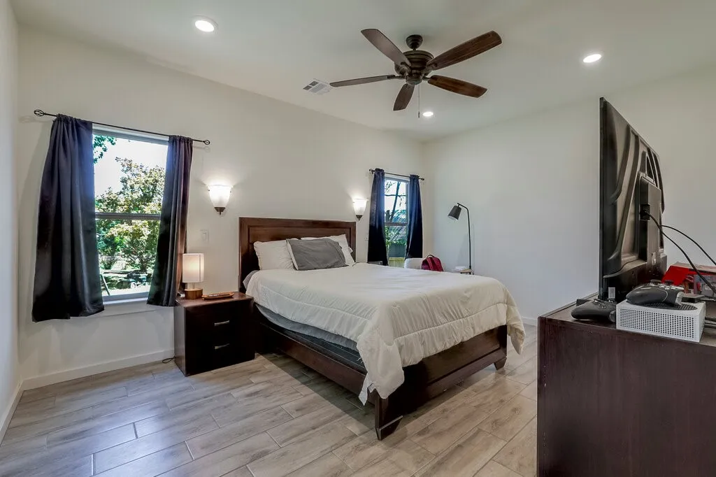 Recessed ceiling lighting, wood-finish flooring, ceiling fan, and wall sconces