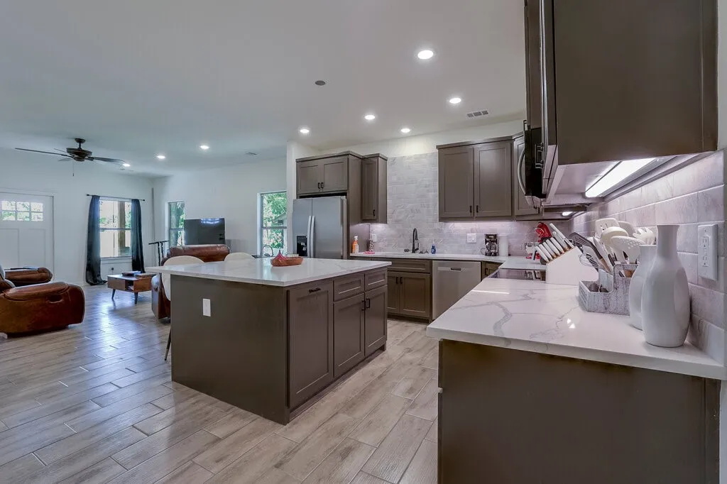 Kitchen with dark cabinetry, light countertops, and a tiled backsplash