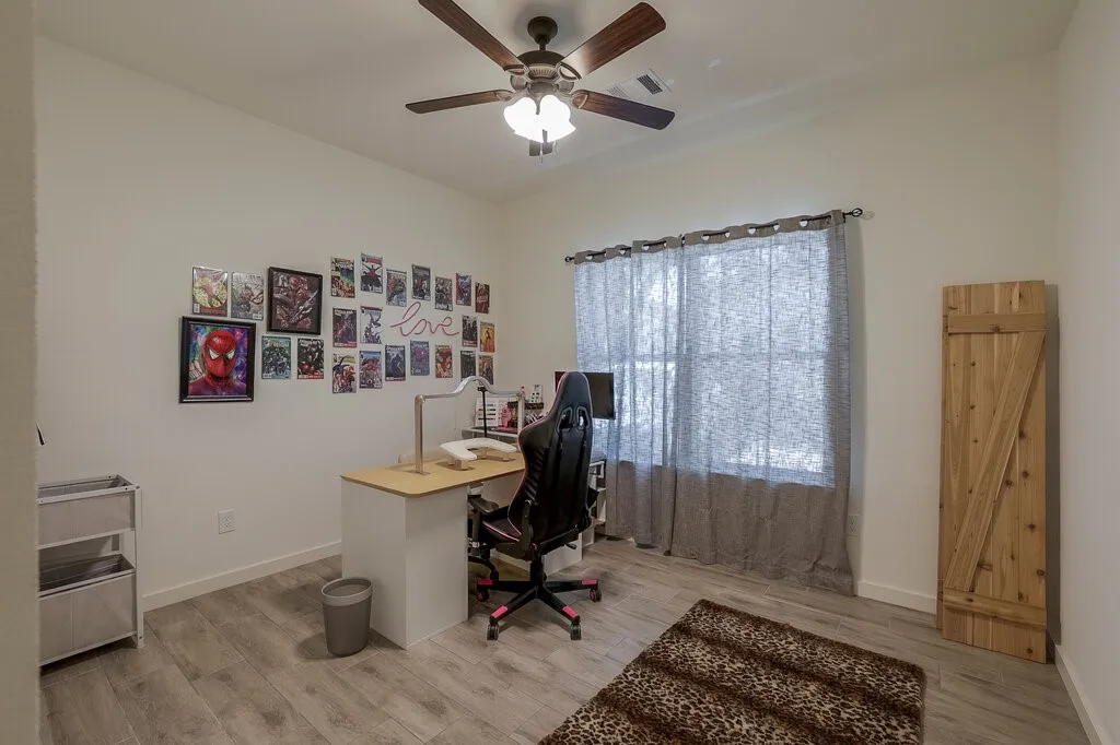 Wood-finish flooring, ceiling fan, and a window with a curtain rod