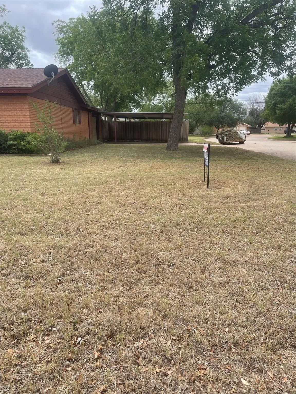 Spacious grounds featuring a level lawn with mature shade trees and established landscaping