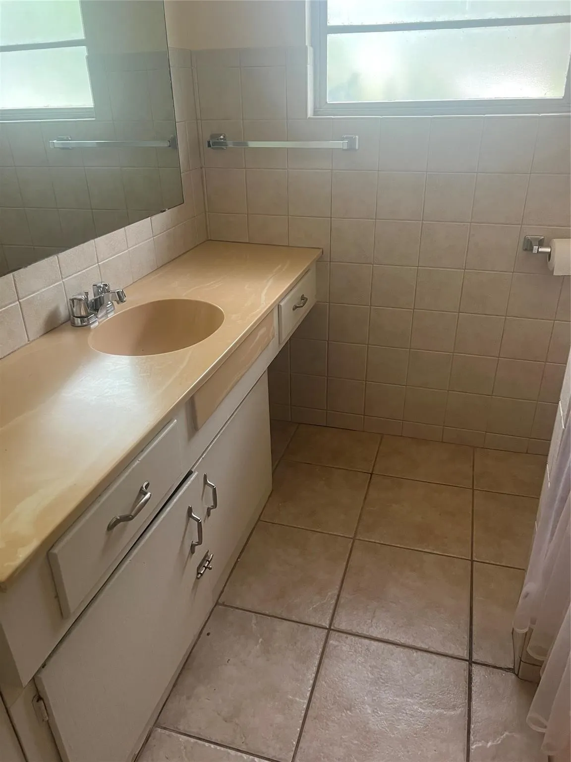 MAIN Bathroom vanity with an integrated sink and base cabinetry, complemented by a large wall mirror