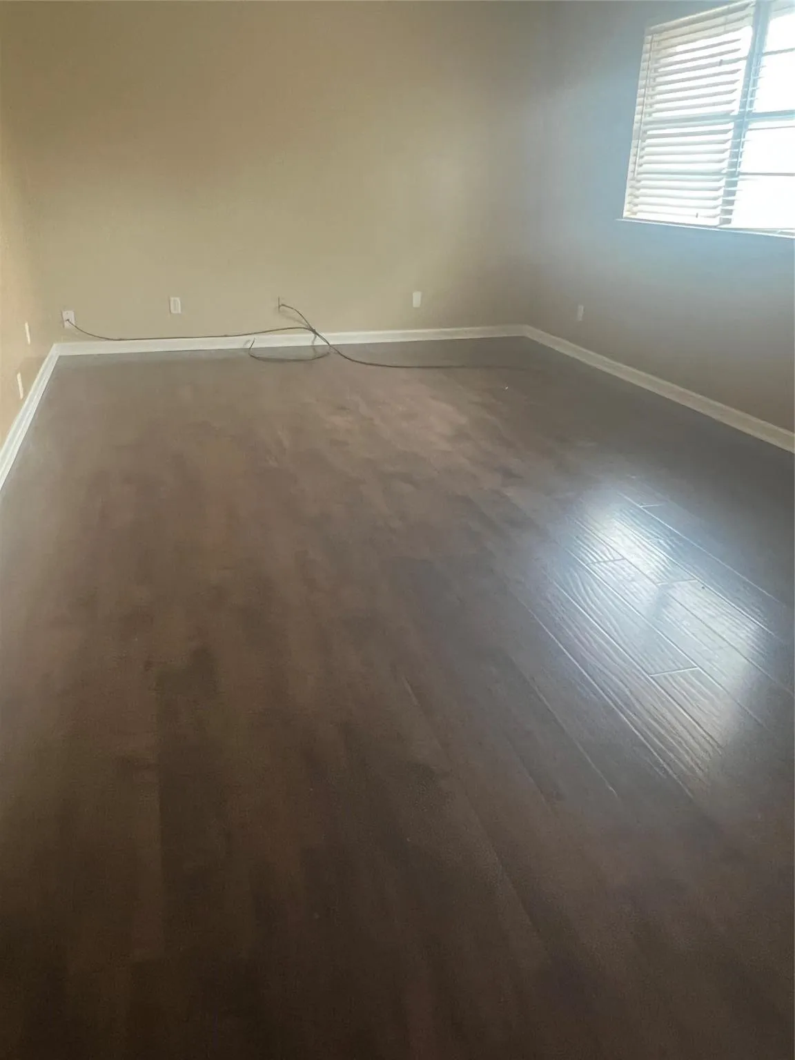 Dark wood-finish flooring with light wall tones and white trim
