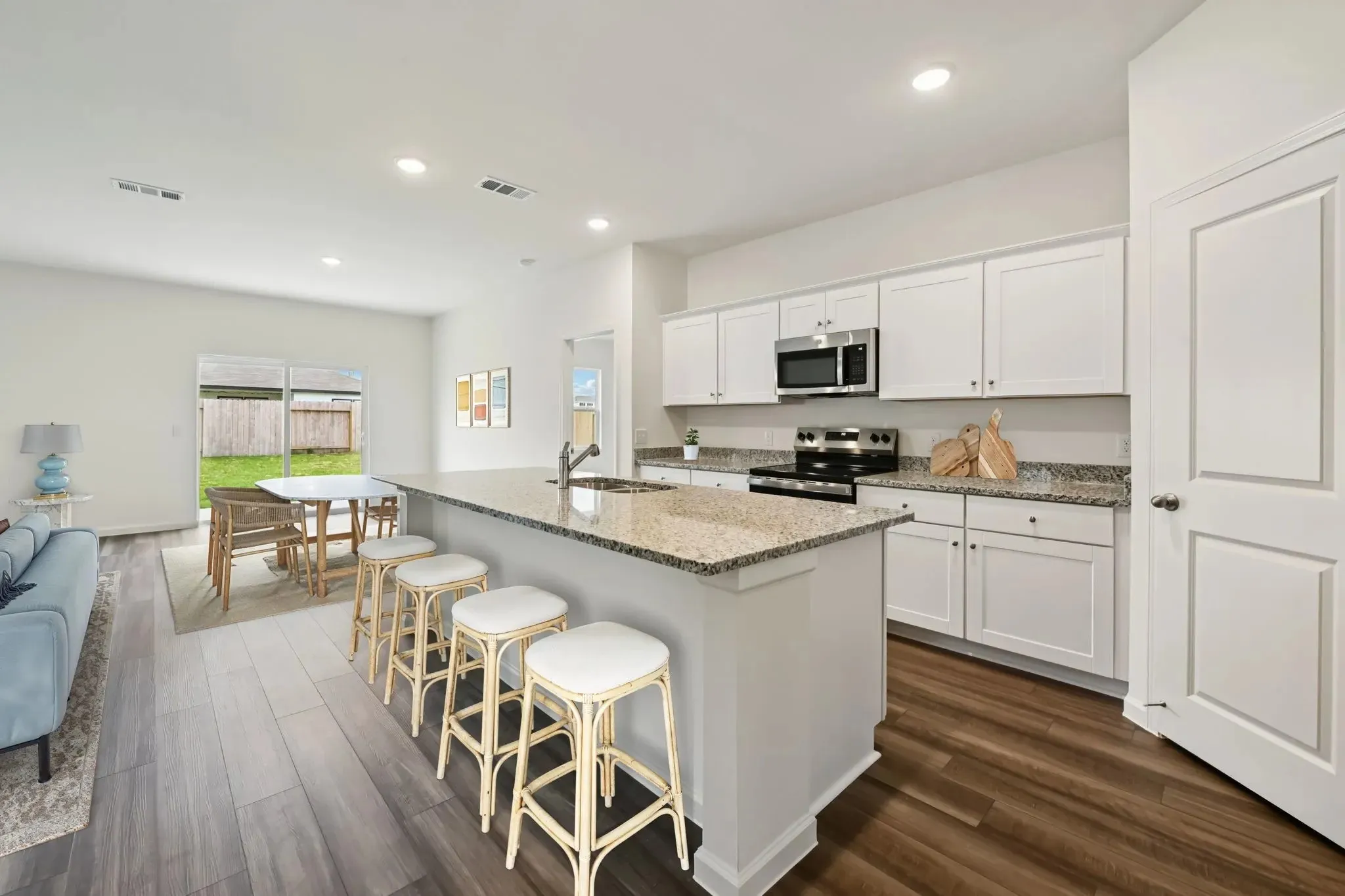 Kitchen with white cabinetry, stainless steel appliances, and stone countertops
