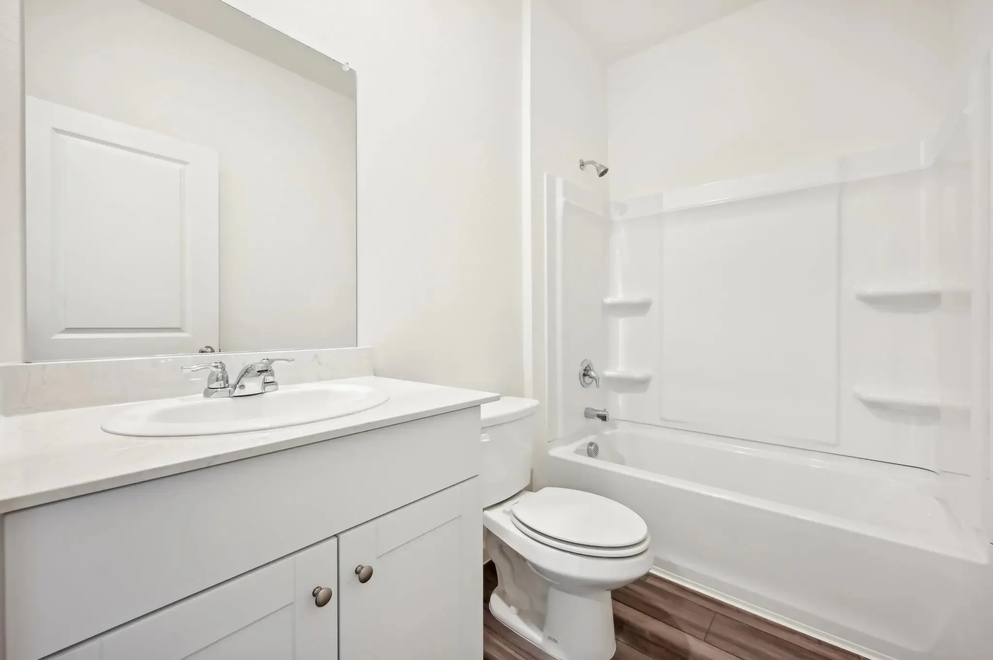 Vanity with an integrated sink, polished chrome faucet, and white countertop
