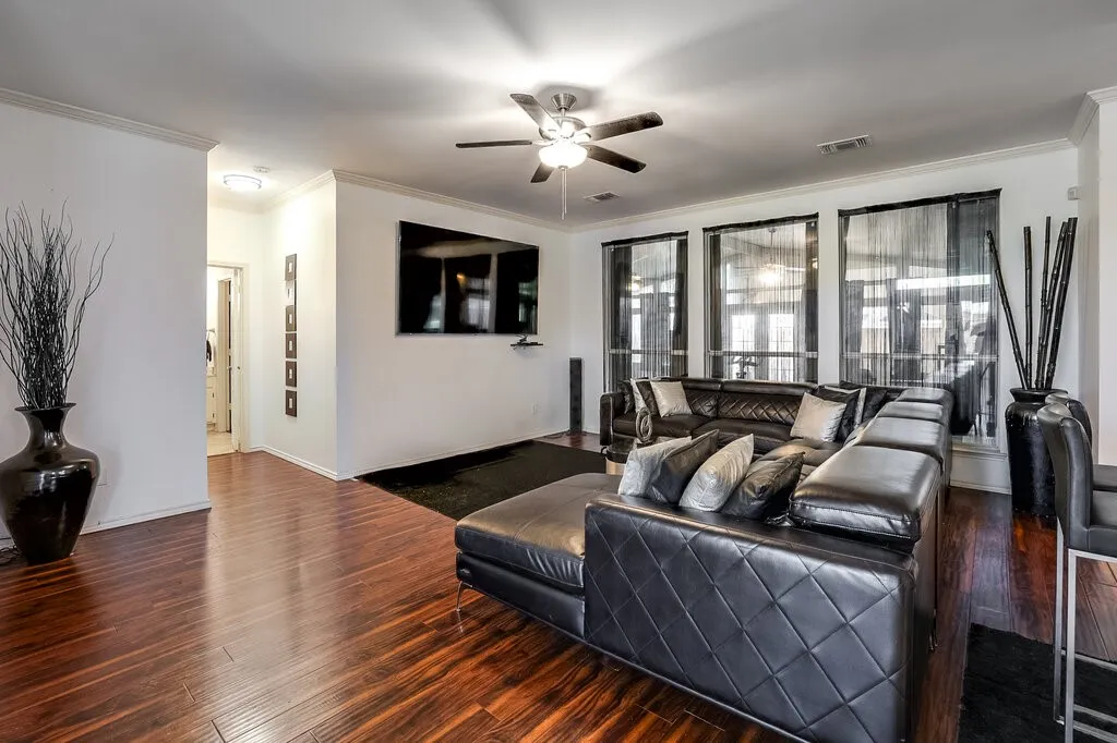 Wood-finish flooring, recessed lighting, ceiling fan, and multiple tall windows