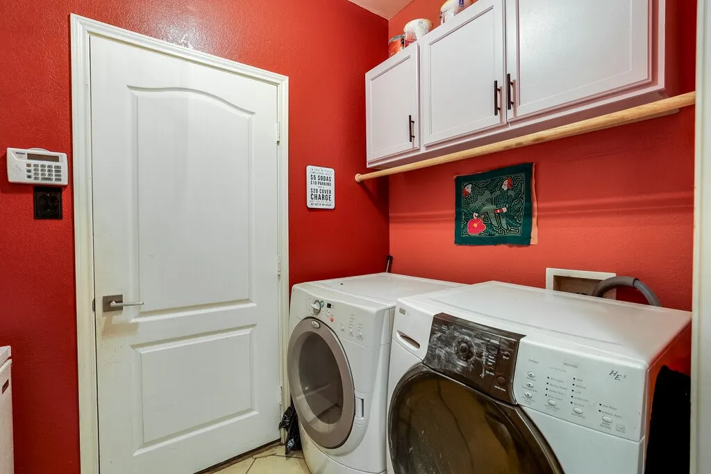 Dedicated laundry area with upper cabinetry and a built-in wooden hanging rod