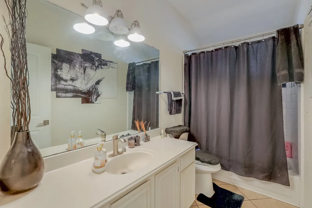 Vanity with an integrated sink, brushed nickel faucet, and a large mirror