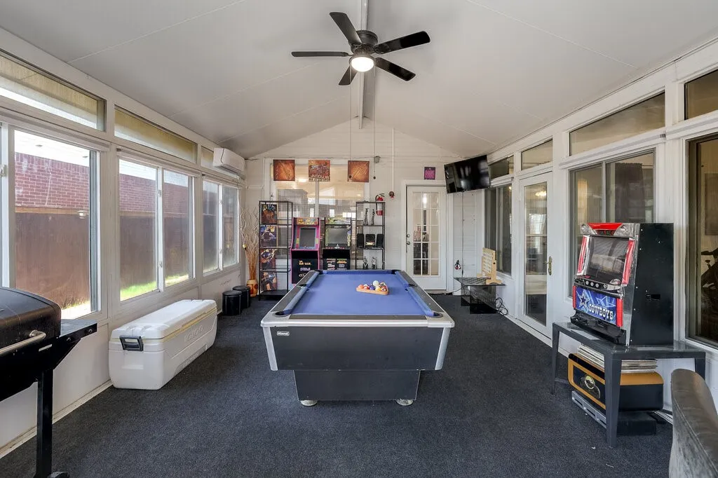 Sunroom with a vaulted ceiling, multiple windows, and a ceiling fan