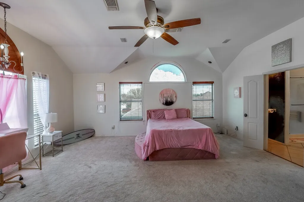 Vaulted ceiling, ceiling fan, arched transom window, recessed lighting, and carpet flooring