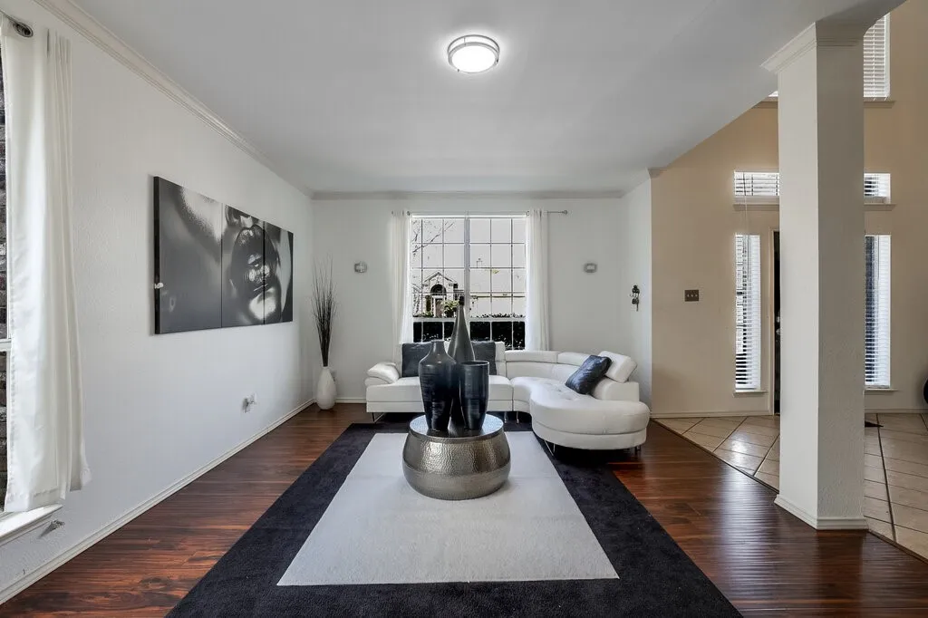 Hardwood-style flooring throughout, crown molding detailing, and a prominent architectural column