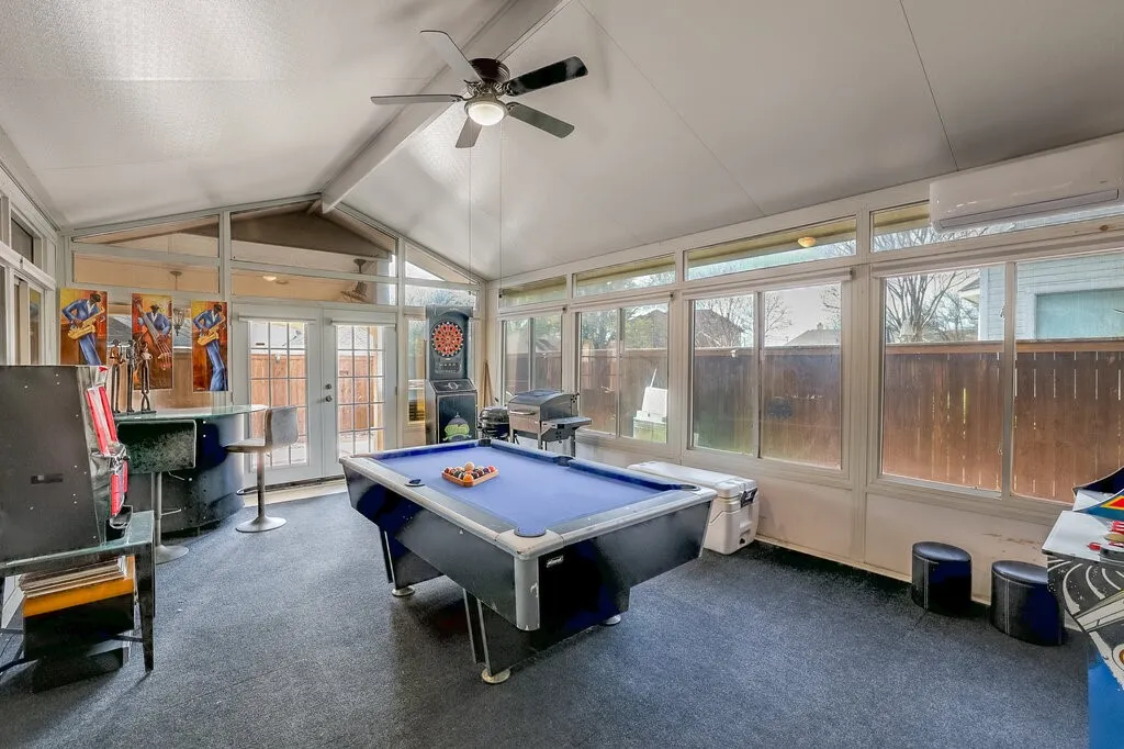 Sunroom with vaulted ceiling, ceiling fan, and extensive windows