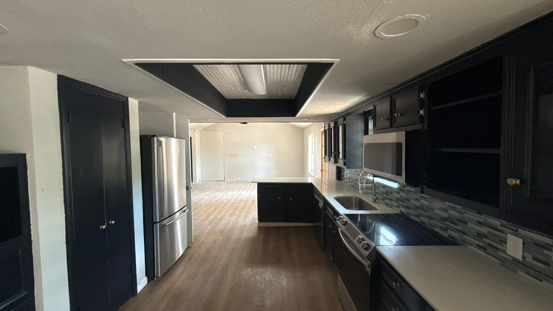 Gourmet kitchen featuring dark cabinetry, stainless steel appliances, light countertops, and a tiled backsplash