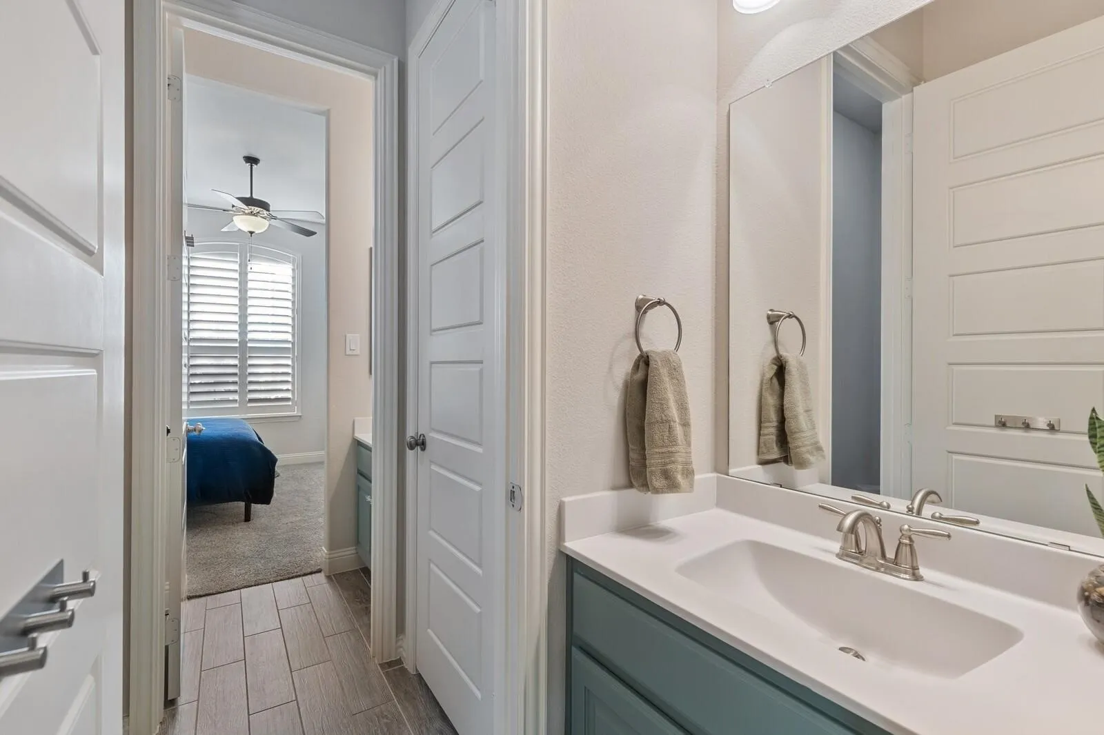 Bathroom vanity with a single basin sink, brushed nickel faucet, and a large mirror