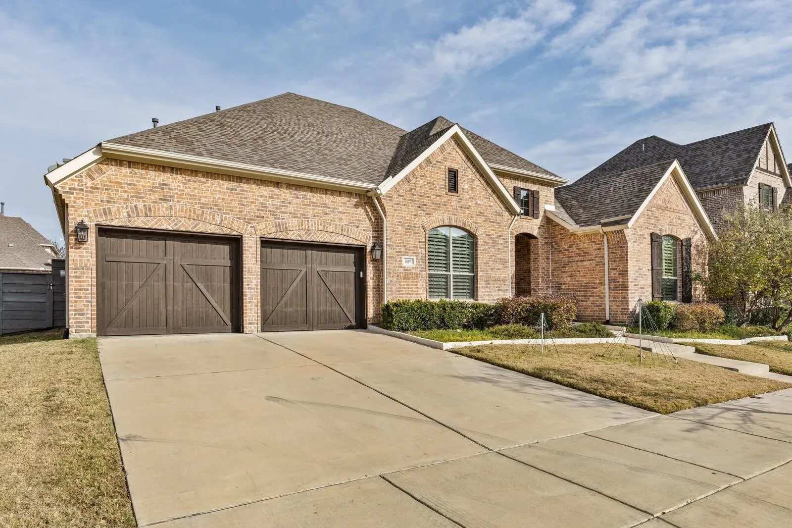 Brick exterior with a shingle roof and a two-car garage