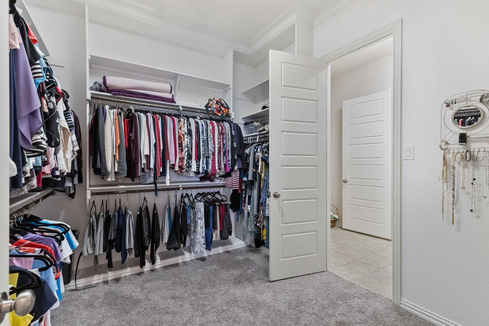 Built-in closet system with multiple hanging rods and shelving