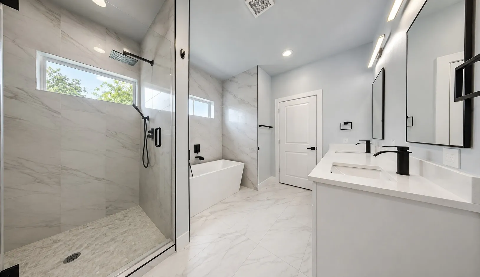 Spacious bathroom featuring a frameless glass shower enclosure, freestanding soaking tub, dual vanity with undermount sinks, and matte black fixtures