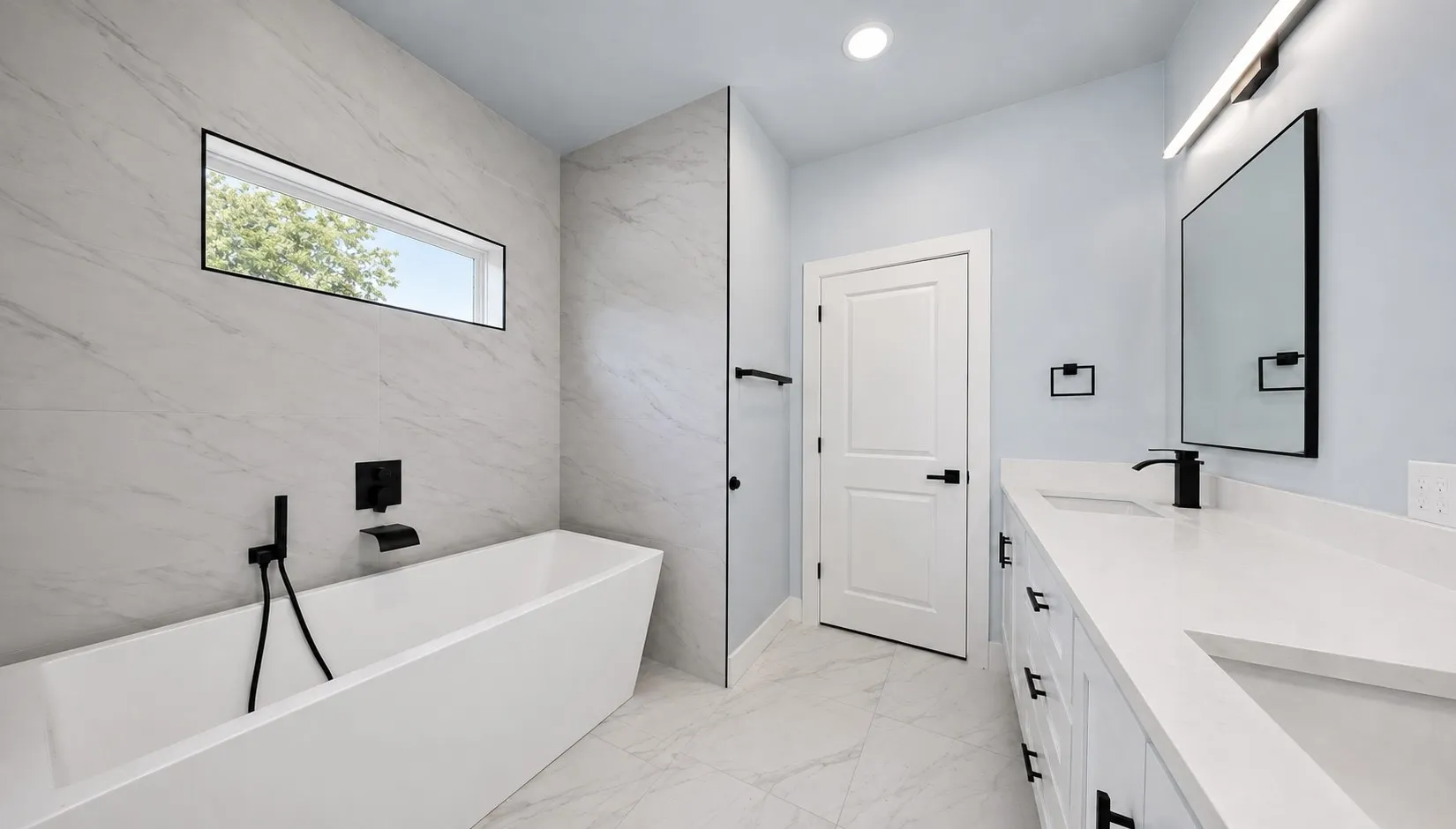 Freestanding soaking tub with wall-mounted matte black fixtures