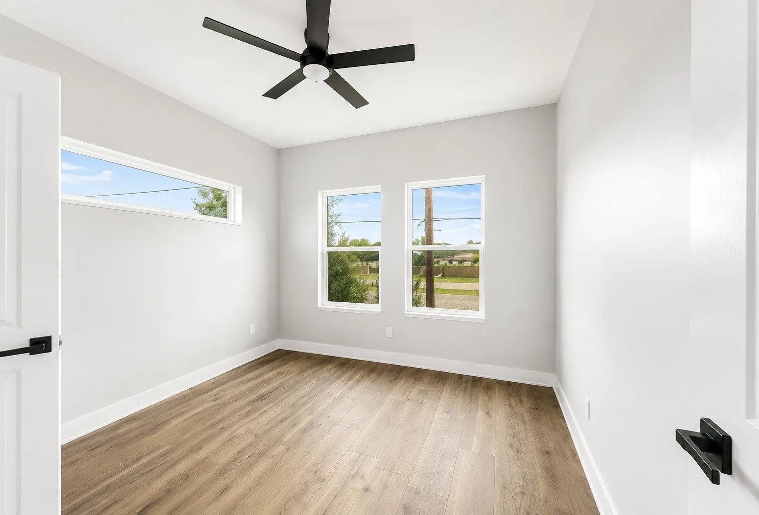 Recessed lighting, wood-finish flooring, ceiling fan, multiple windows, and white trim
