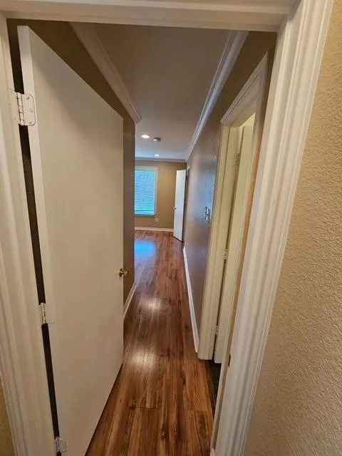 Corridor with crown molding, hardwood / wood-style floors, and recessed lighting