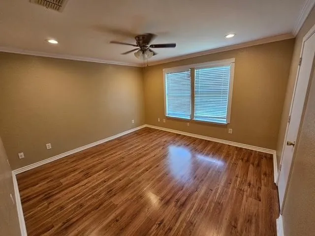 Unfurnished room with ornamental molding, ceiling fan, wood finished floors, and recessed lighting