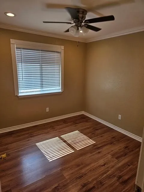 Empty room featuring crown molding, a ceiling fan, wood finished floors, and recessed lighting