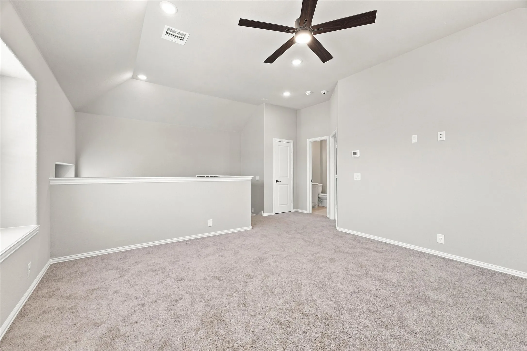 Carpeted flooring, vaulted ceiling, recessed lighting, ceiling fan, and built-in shelving