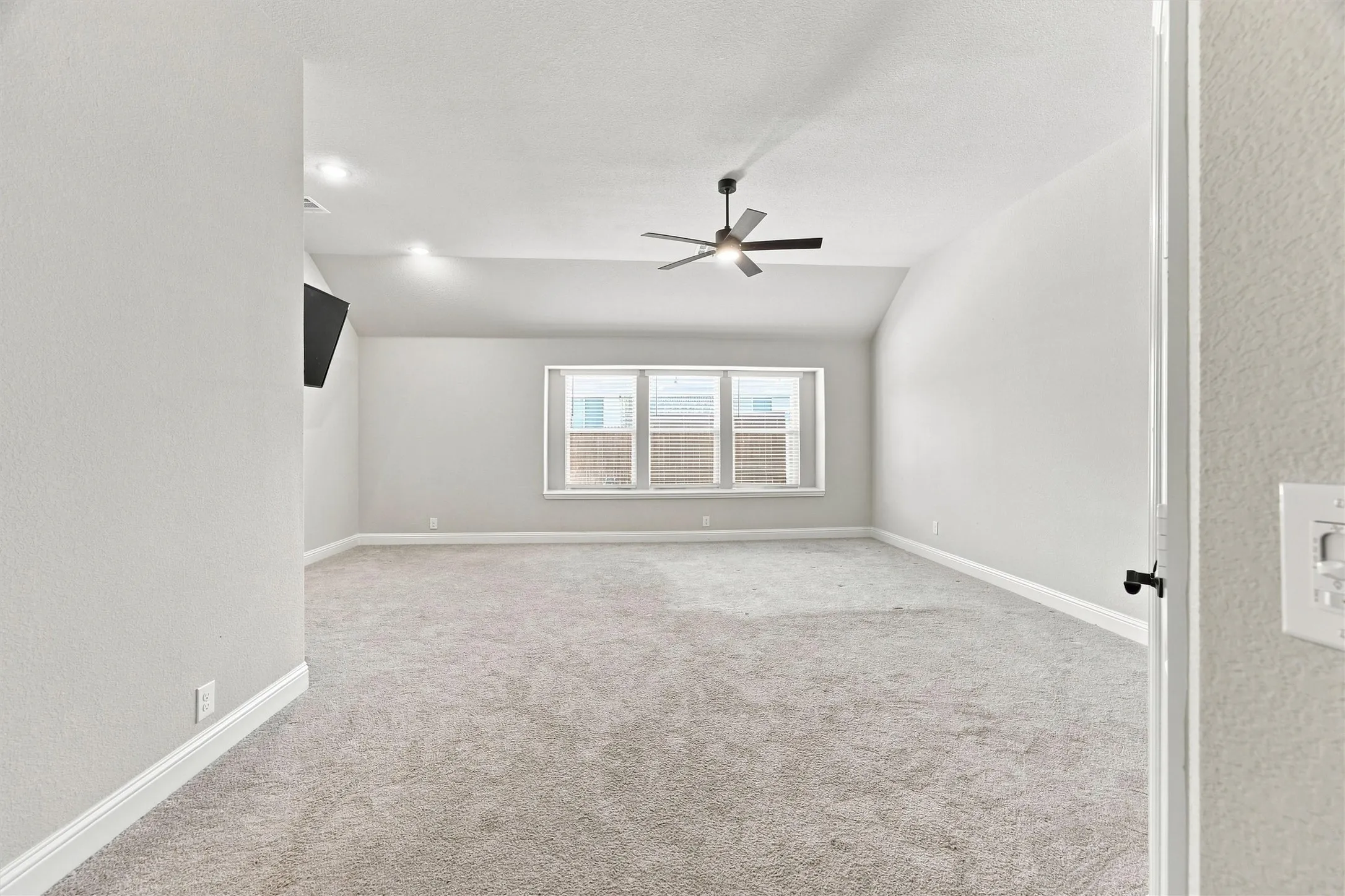 Spacious bedroom flooded with natural light from triple casement windows