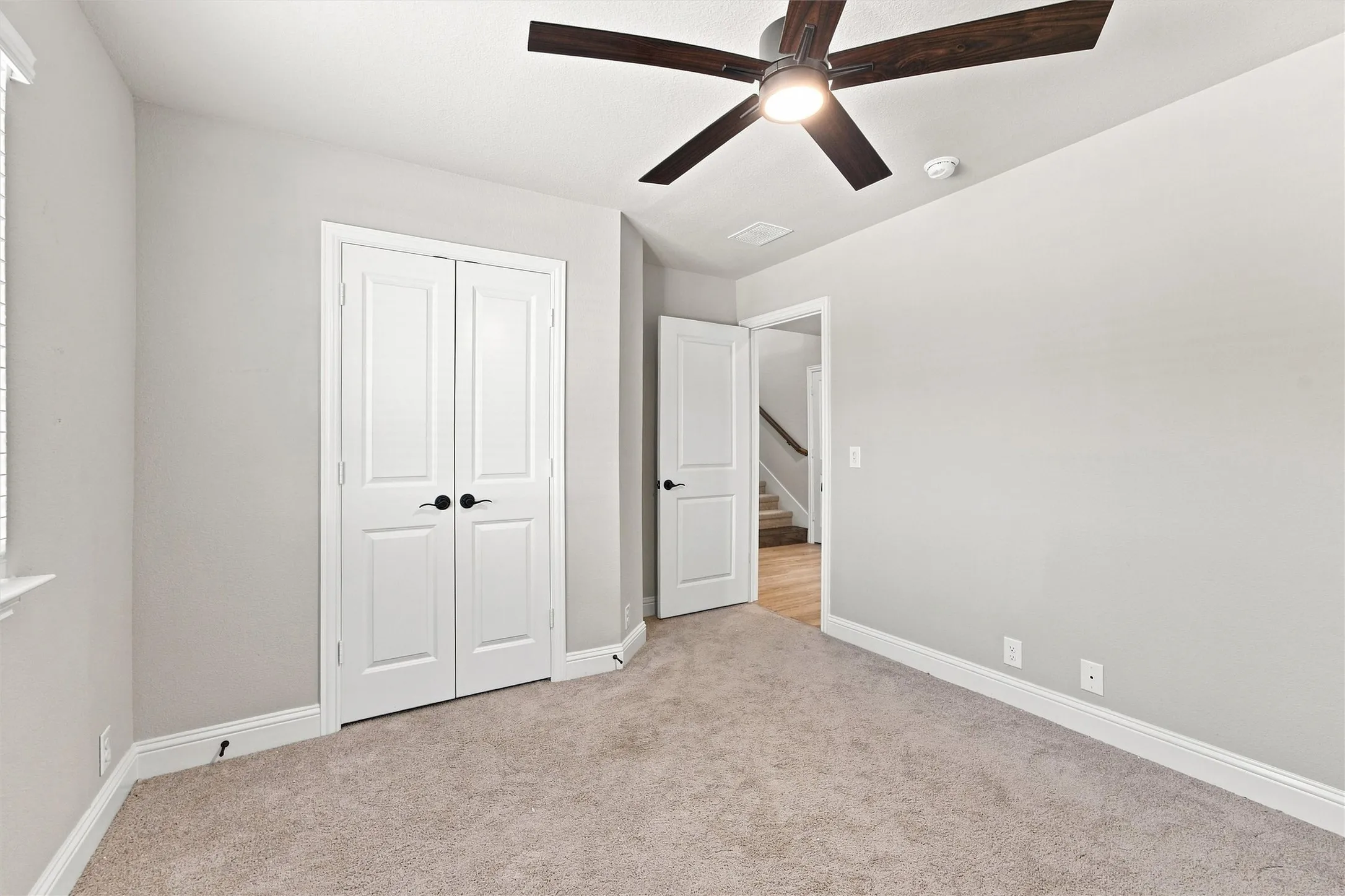 Soft gray walls complement carpeted flooring