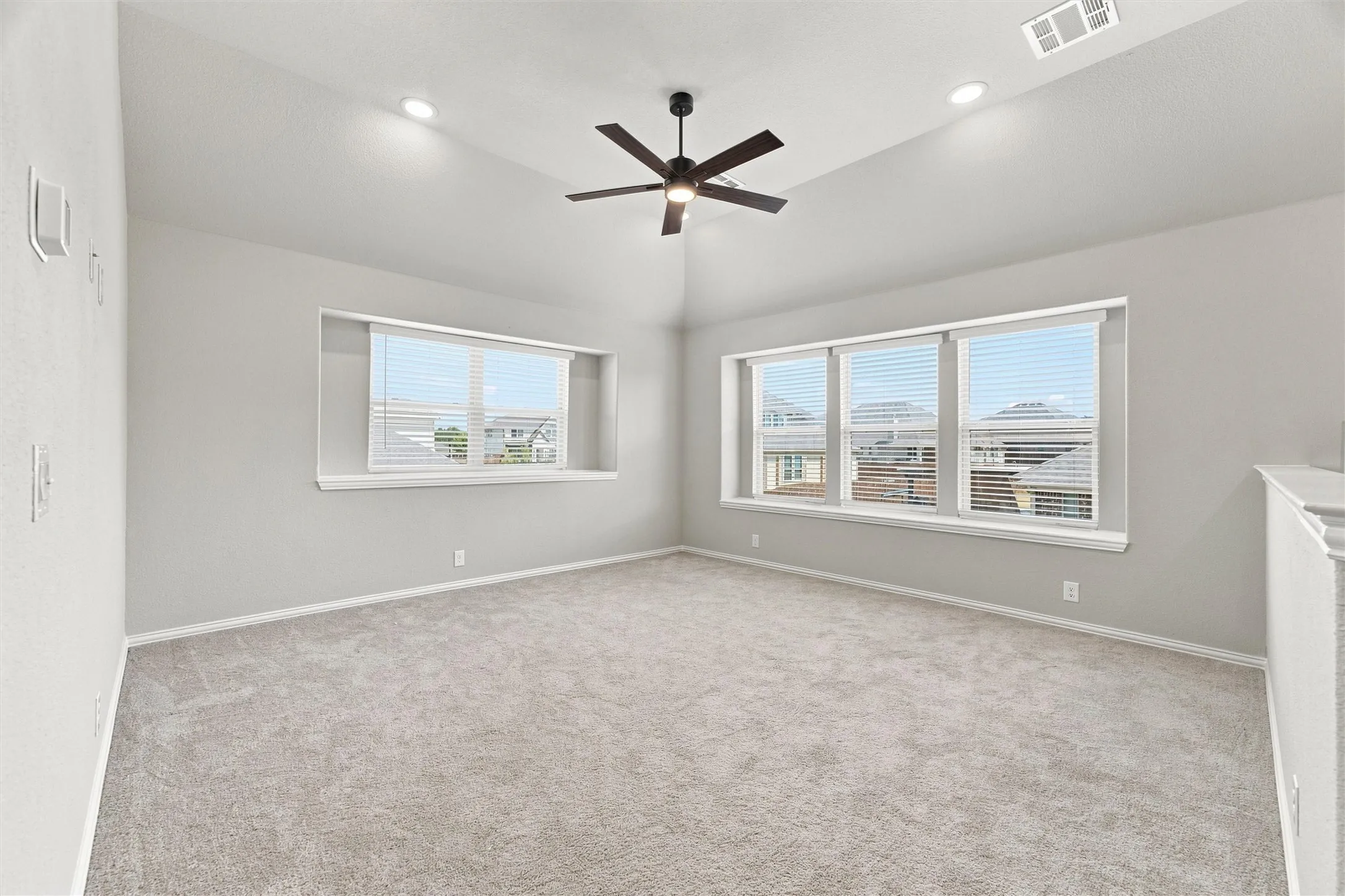 Vaulted ceiling featuring a ceiling fan, recessed lighting, and multiple windows with blinds