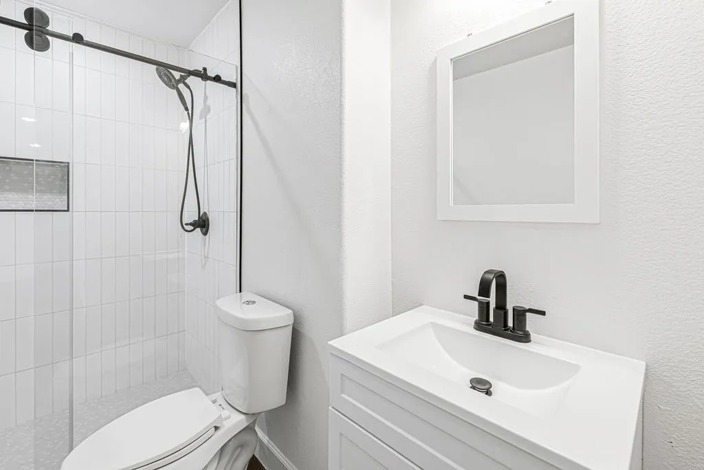 Renovated bathroom with new tiled, walk-in shower, new toilet, new vanity and sink