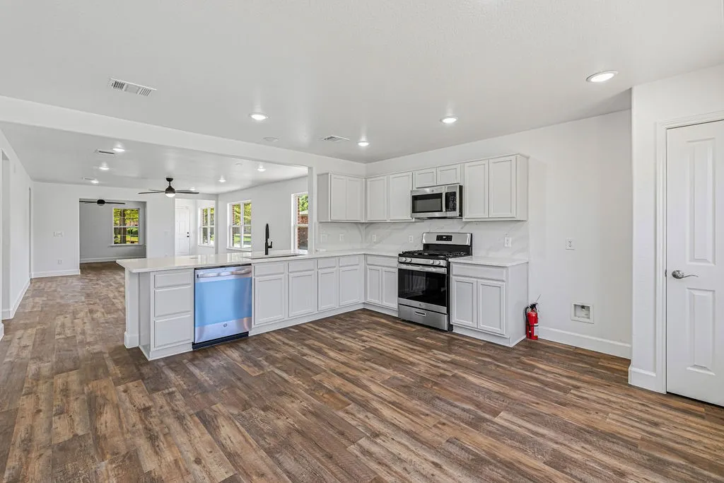 Updated kitchen features quartz countertops and backslash, new appliances, and refreshed white cabinetry