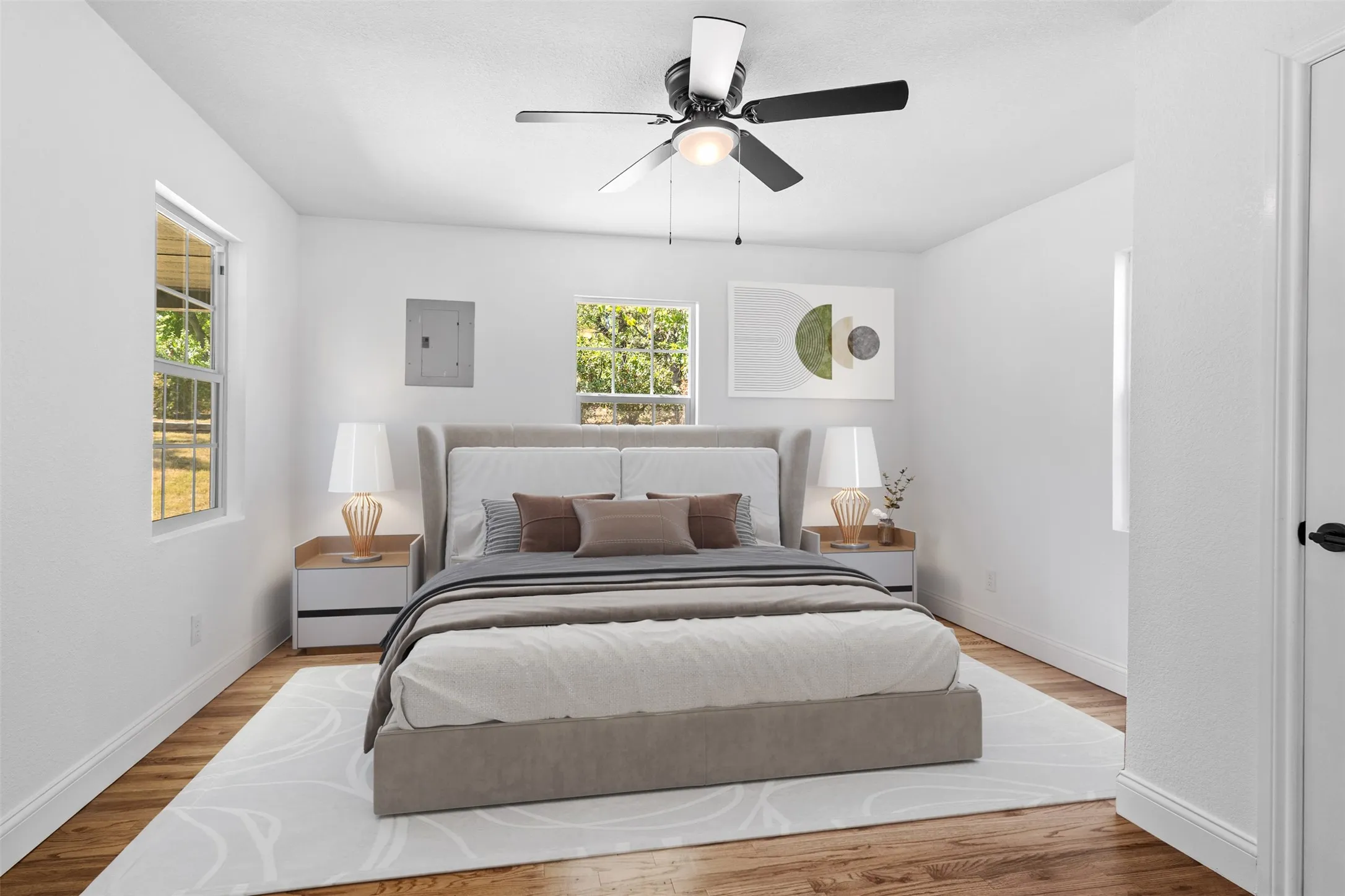 Wood-finish flooring, white painted walls, and a ceiling fan with integrated lighting