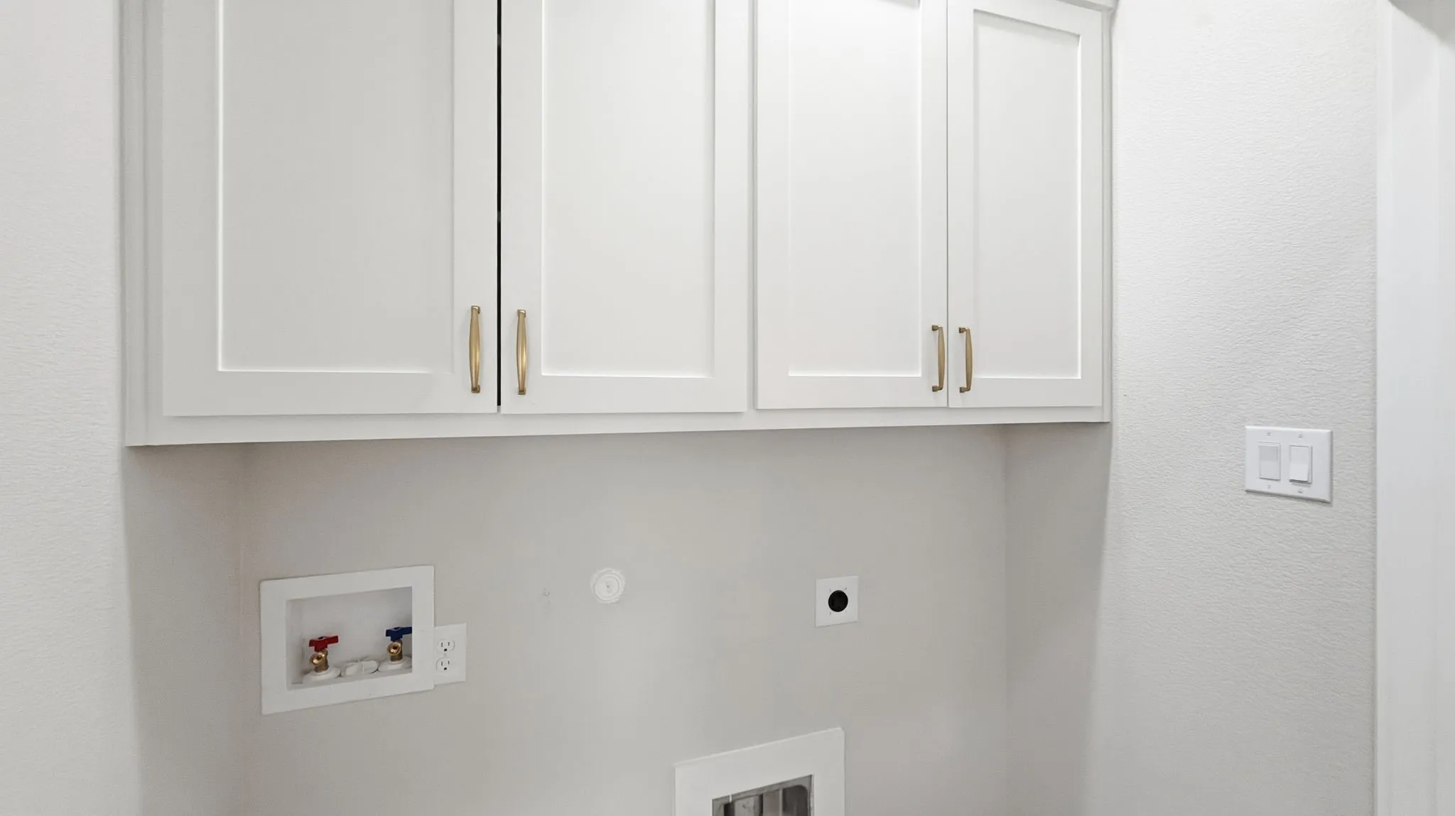 Separate laundry room with built in cabinets