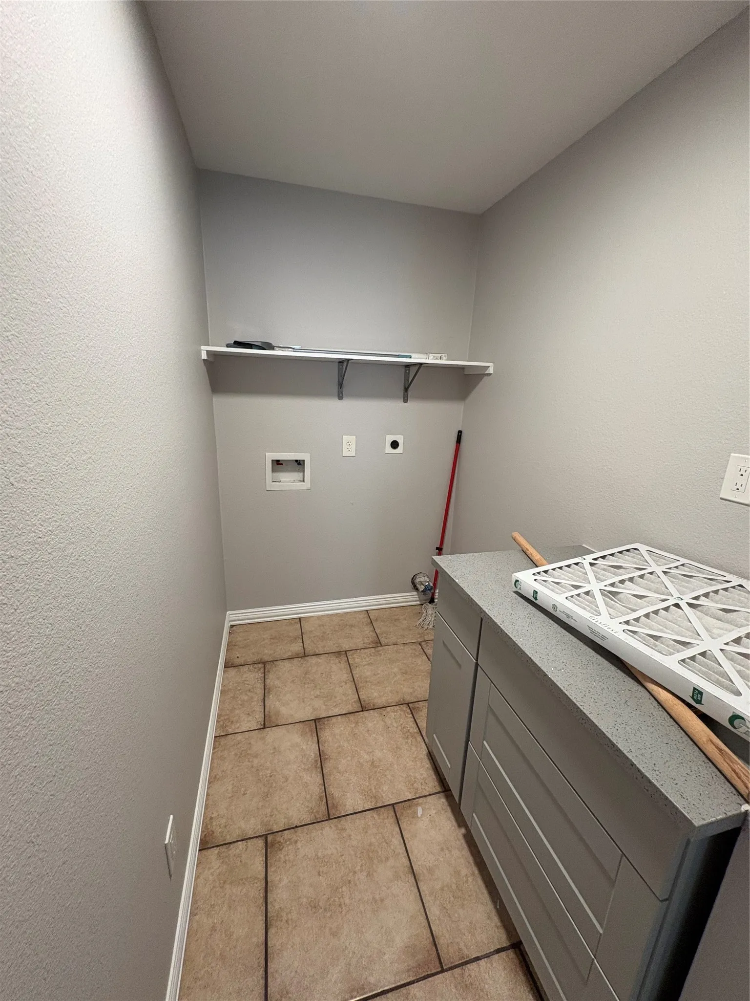Tile flooring, built-in shelving, and a built-in cabinet with a countertop