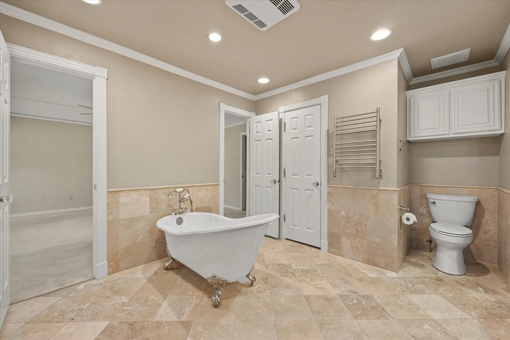 Over the toilet cabinets, heated towel bar, and closets on each side of this spa type bath.