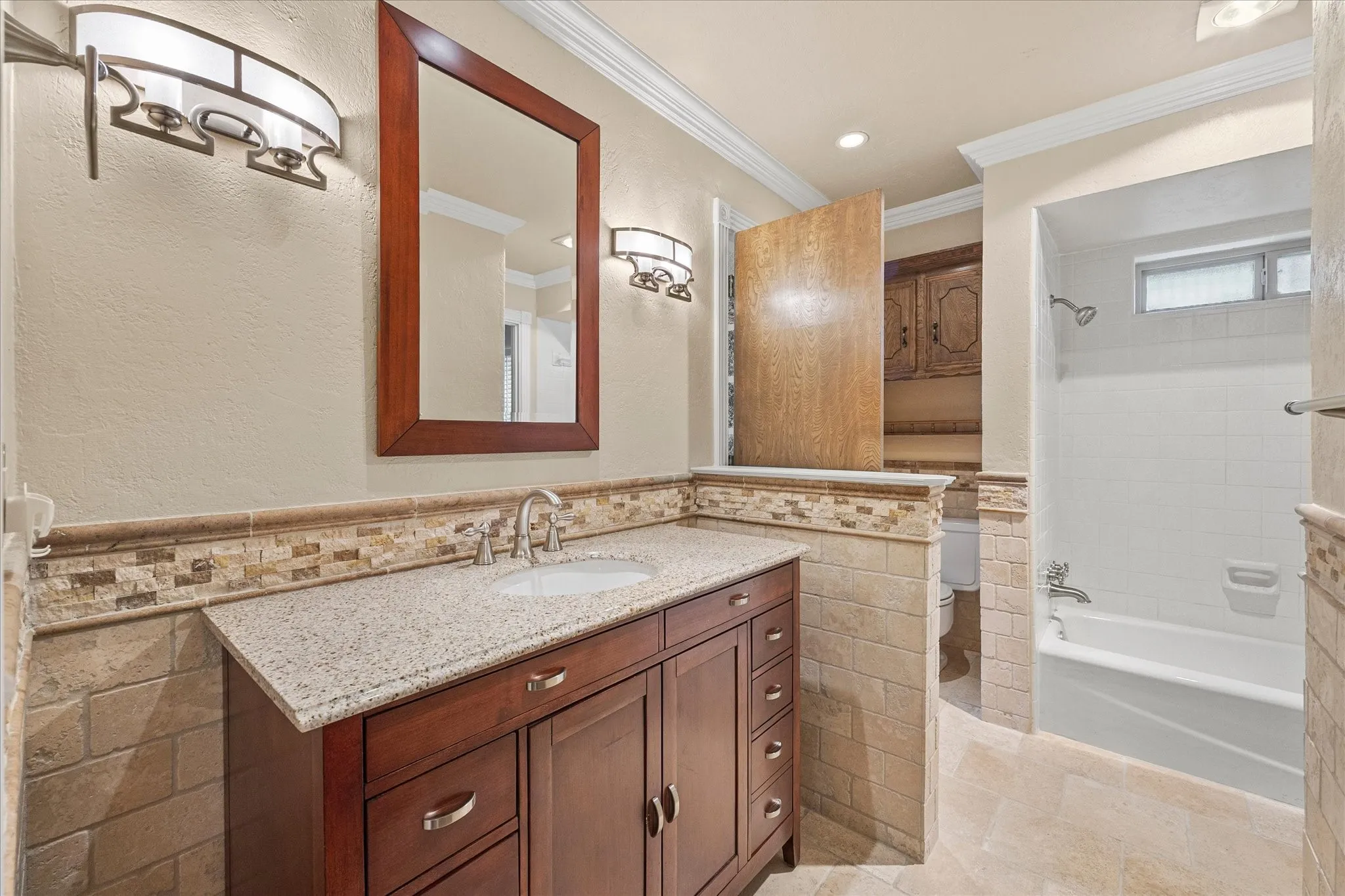 Full bath, decorative tile, neutral colors and lovely cabinetry.