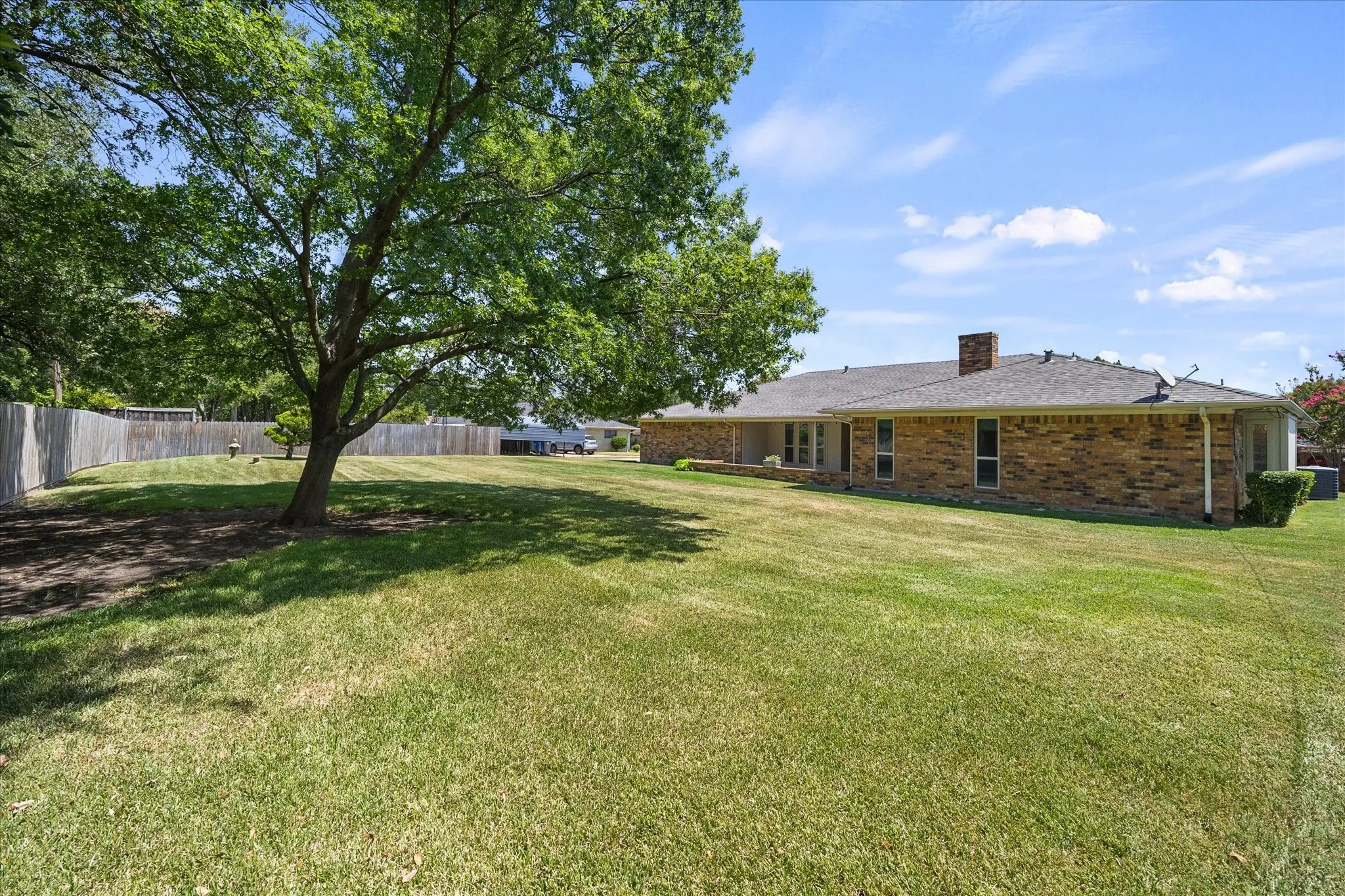 Expansive backyard with mature shade tree and plenty of room for outdoor entertaining, play, or relaxation.