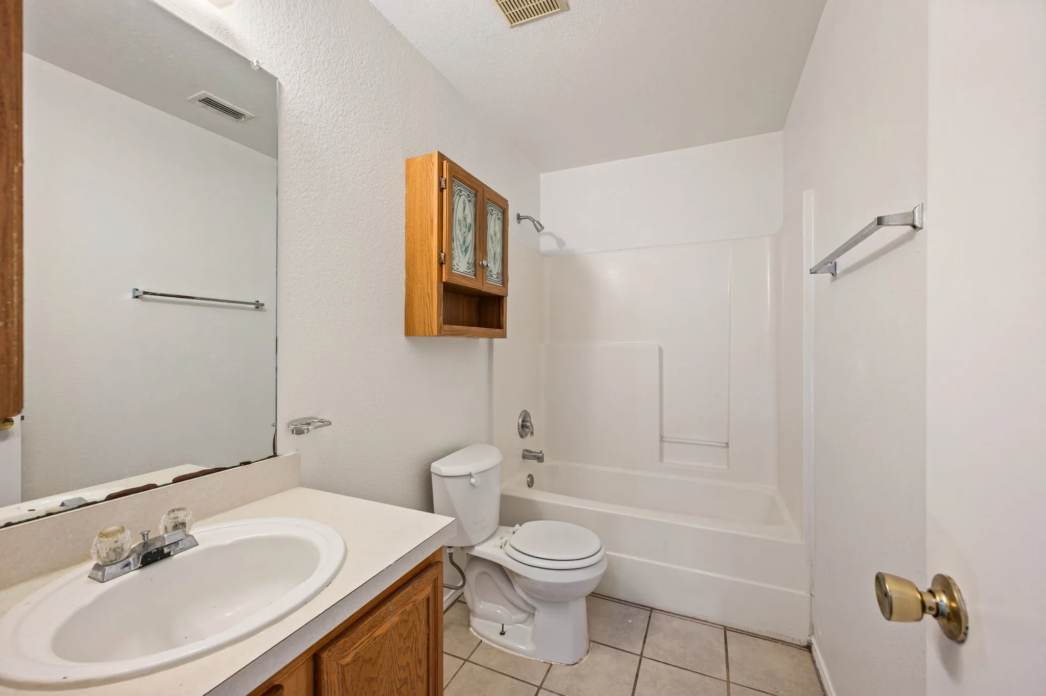 Vanity with an integrated sink, wood-finish cabinetry, and a full-width mirror