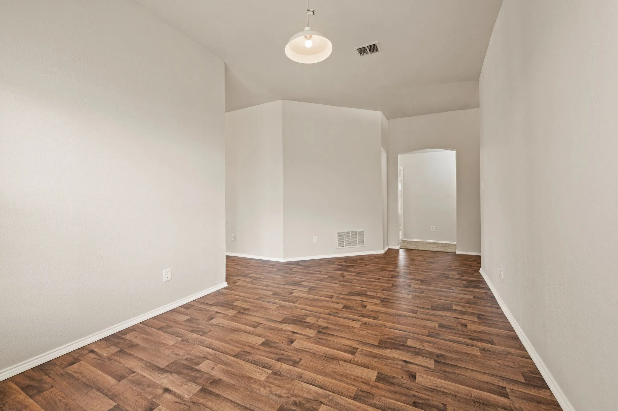 Wood-finish flooring throughout, complemented by light-toned wall finishes and a ceiling-mounted light fixture