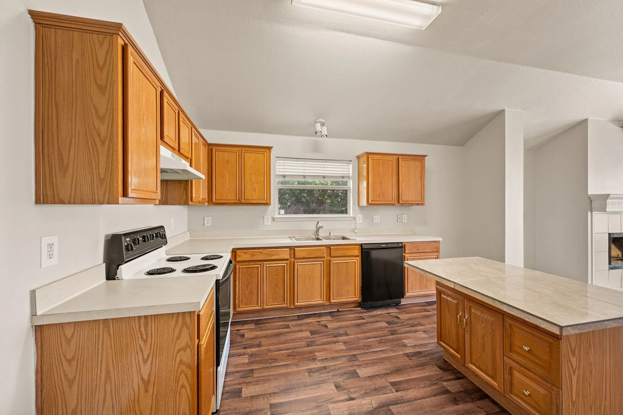 Kitchen featuring wood-finish flooring, wood cabinetry, white countertops, and a central island