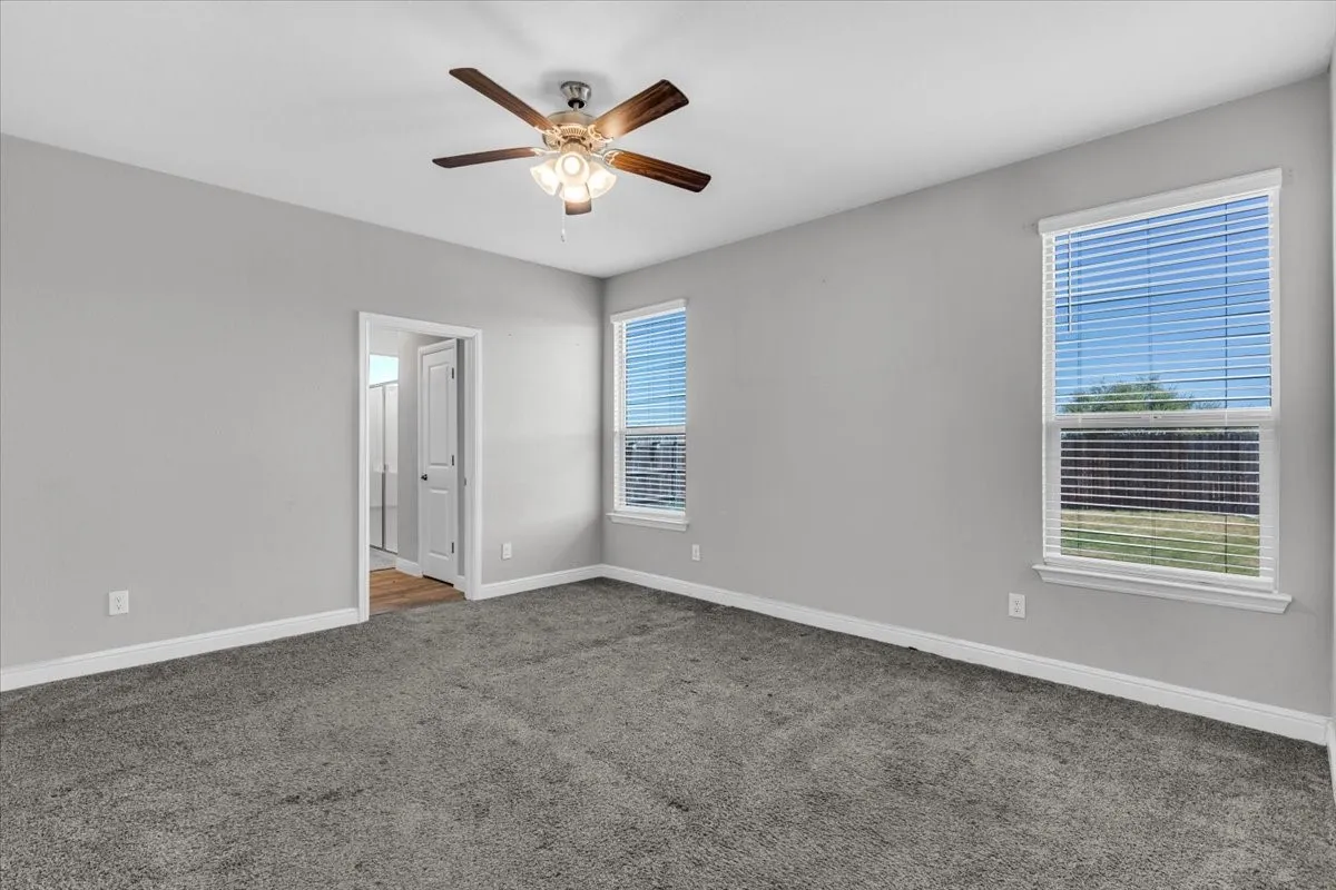 Spacious room featuring gray carpeting, light gray wall paint, and white trim