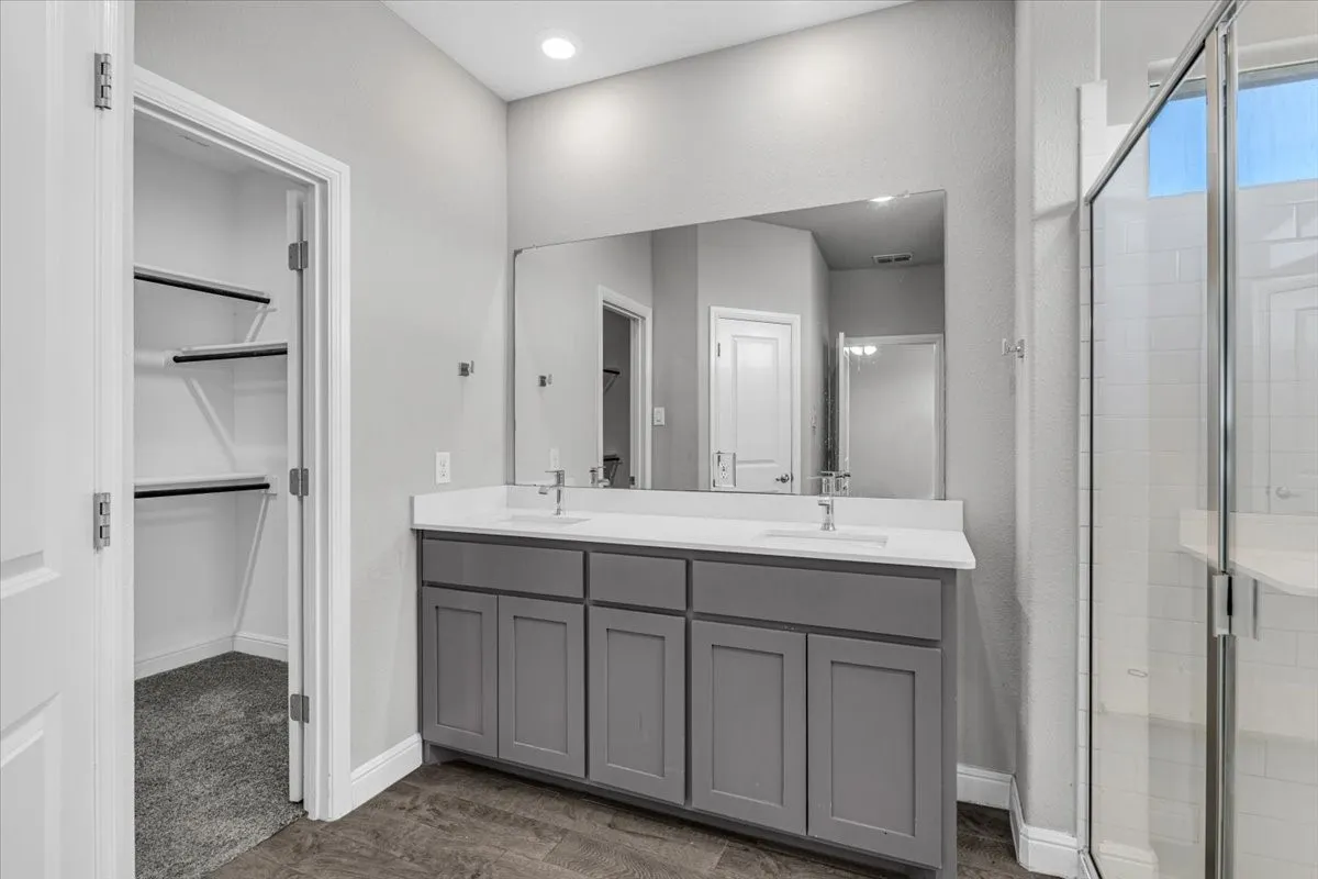 Dual vanity with gray cabinetry, white countertops, and integrated sinks