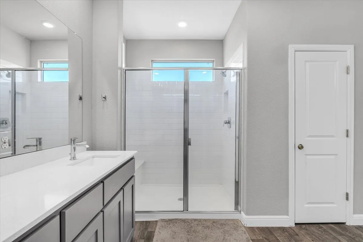 Double vanity with undermount sinks, single-handle faucets, and gray cabinetry