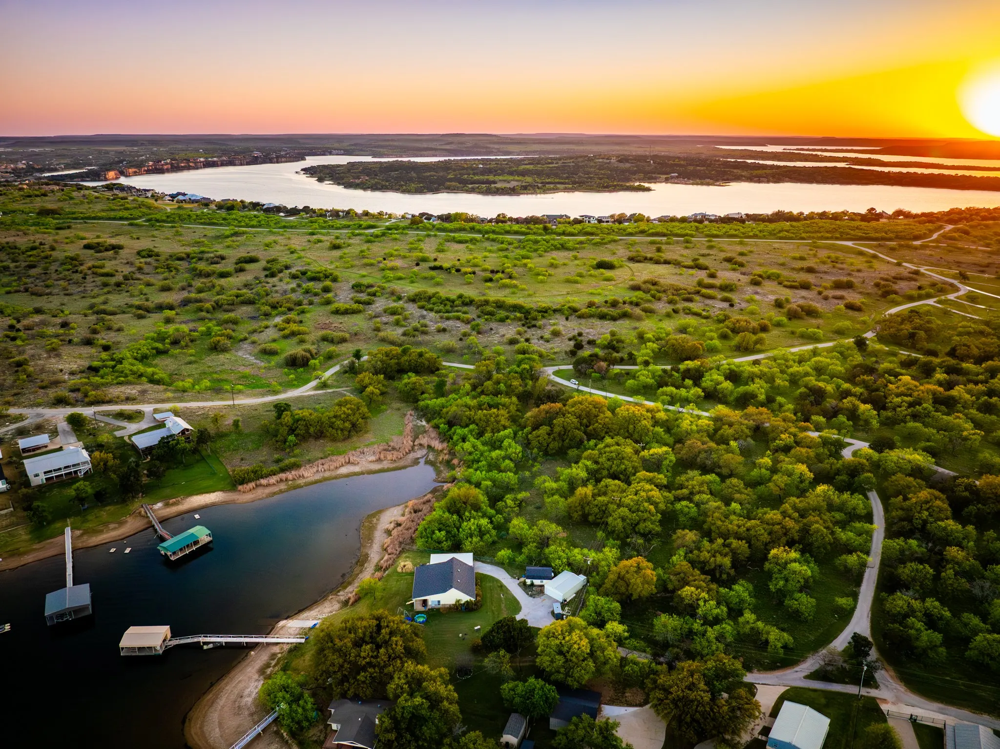 Expansive waterfront property featuring multiple boat docks, a private shoreline, and lush, mature trees