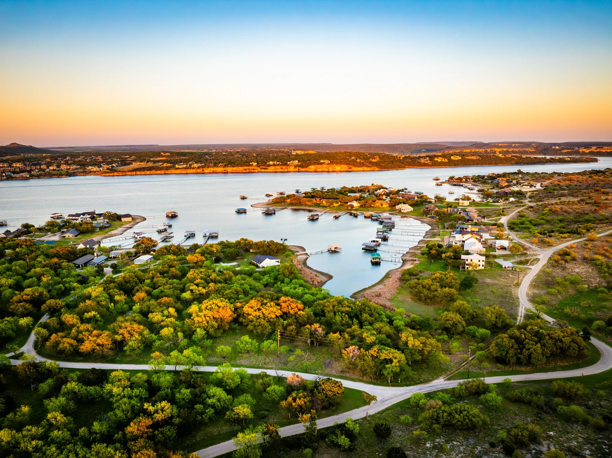 Aerial perspective showcasing extensive waterfront, surrounding natural landscape, and residential properties