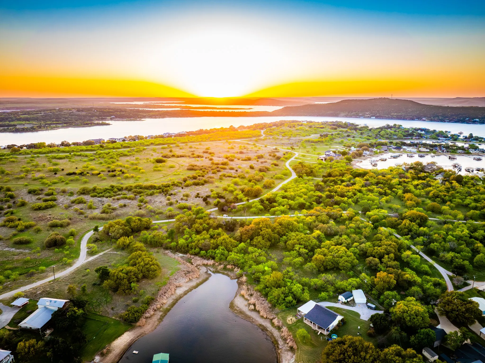Expansive water frontage, multiple structures, and varied terrain with lush vegetation