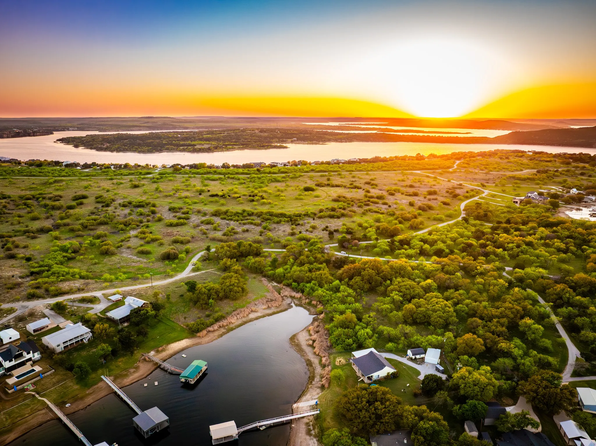 Expansive waterfront property featuring direct water access, multiple private boat docks, and lush, mature trees