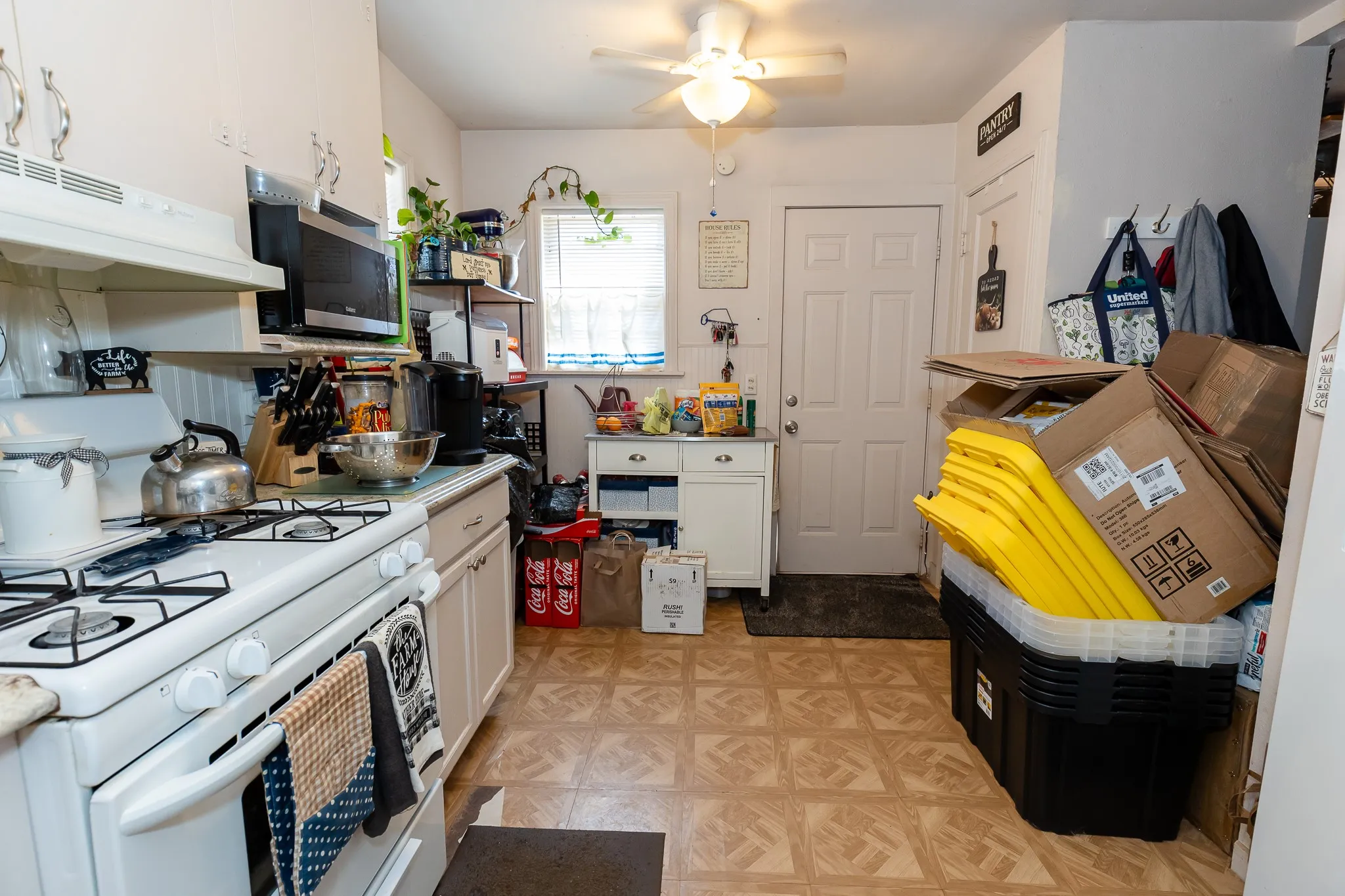 Kitchen featuring a white gas range, white cabinetry, and a ceiling fan with integrated lighting